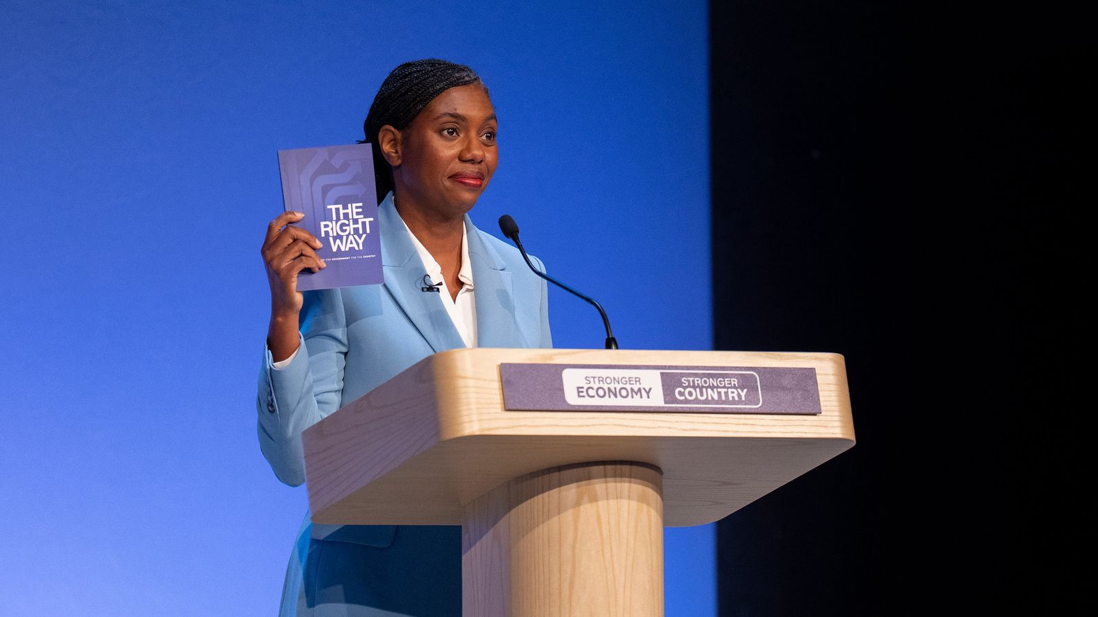 Kemi Badenoch holding The Right Way at a lectern